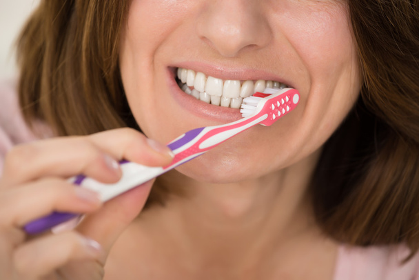 Woman Brushing Teeth With Toothbrush - 写真・画像