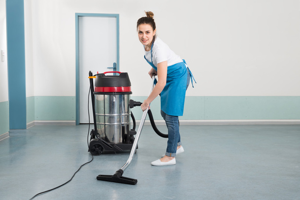 Female Janitor  With Vacuum Cleaner - 写真・画像