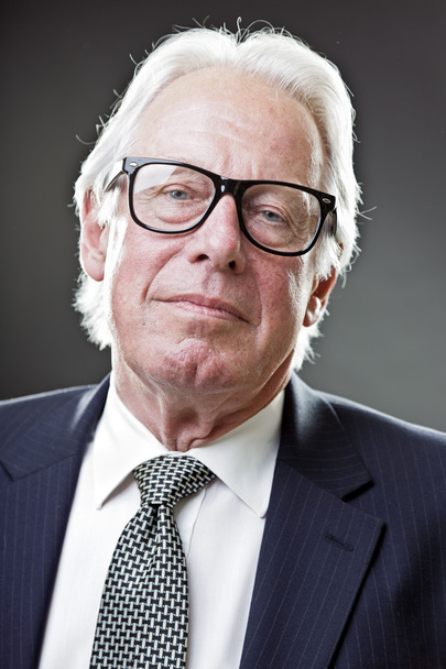 Senior-Geschäftsmann mit Vintage-Brille in dunkelblauem Anzug und Krawatte - Foto, Bild