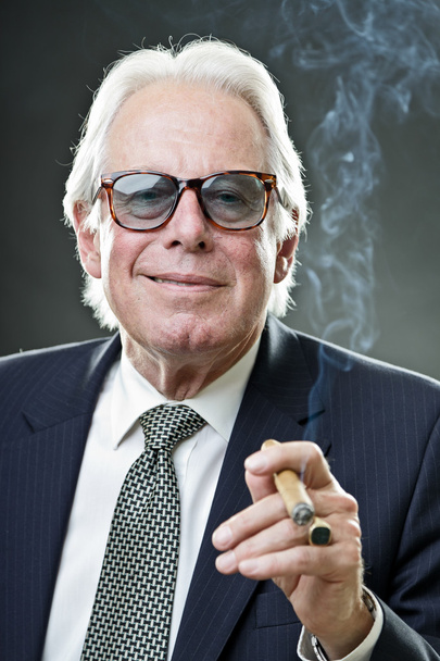 Senior-Geschäftsmann Zigarre rauchend mit Vintage-Sonnenbrille und blauem Anzug mit Krawatte. - Foto, Bild
