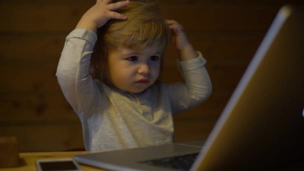4K Cute serious child works with a laptop - Imágenes, Vídeo
