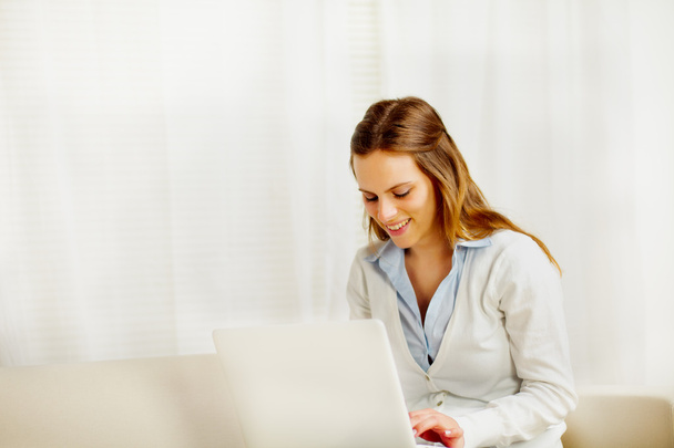 Friendly young woman working on laptop - Foto, imagen
