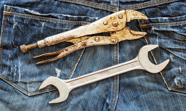 Schraubenschlüssel und Schlüssel auf blauem Jeans-Hintergrund. - Foto, Bild