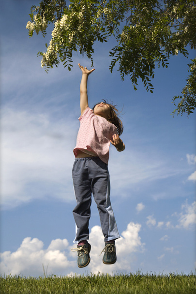 Jump of little girl and tree in the spring - 写真・画像