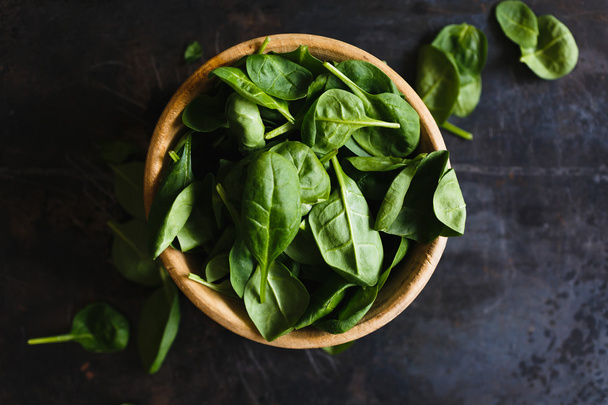 Fresh spinach leaves in a wooden bowl - Foto, Imagen