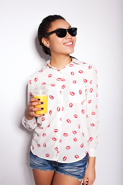 Menina bonita posando no estúdio em um fundo branco. beber suco de laranja
 - Foto, Imagem