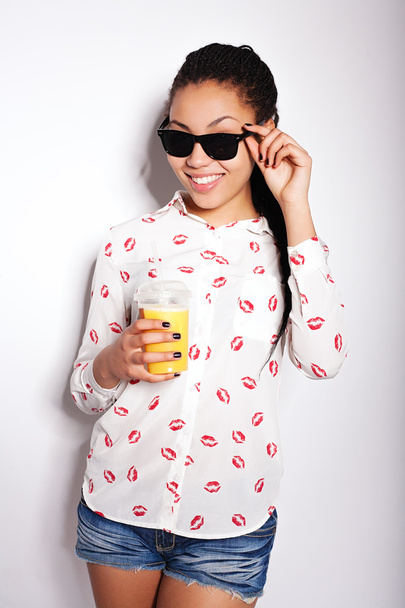 Bella ragazza in posa in studio su uno sfondo bianco. bere succo d'arancia
 - Foto, immagini