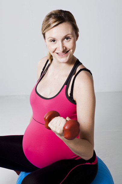 Pregnant woman exercising with dumbbells - Fotó, kép