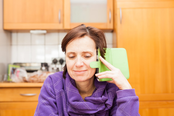 Ženy nad 40 let s telefonem v kuchyni - Fotografie, Obrázek