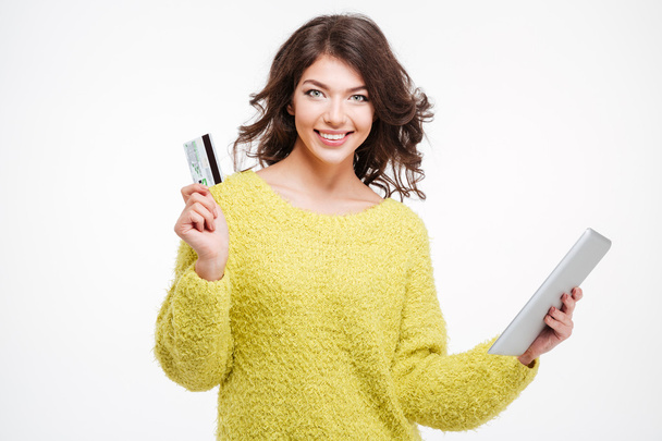 Smiling woman holding bank card and tablet computer - Фото, изображение