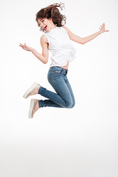 Full length portrait of a cheerful woman jumping - Фото, зображення
