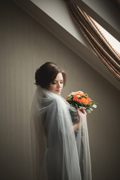 Роскошная невеста в черном халате позирует при подготовке к свадьбе
 - Фото, изображение