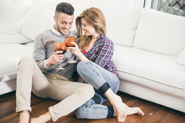 Young couple drinking wine in the living room - Foto, immagini