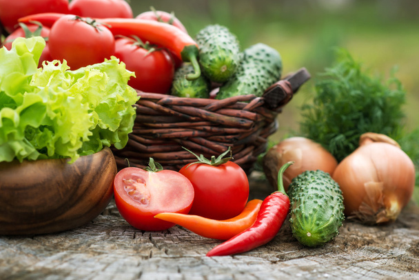 Košík a dřevěná deska s čerstvou zeleninou (rajčata, okurka - Fotografie, Obrázek