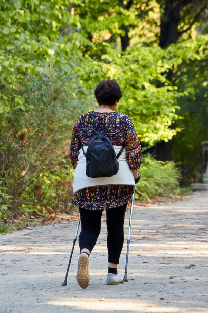 Middle-aged woman walking in park - Photo, Image