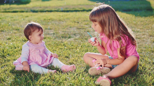Two little girls playing on lawn - Footage, Video