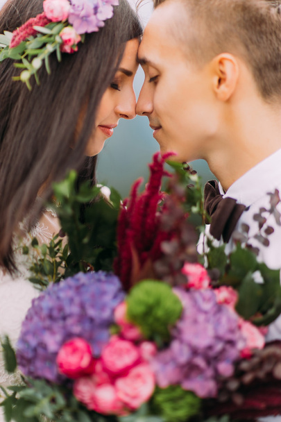 Beautiful wedding couple with purple flowers close up - Zdjęcie, obraz