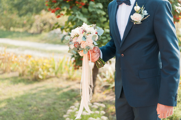 Прекрасный свадебный букет в руках жениха
 - Фото, изображение