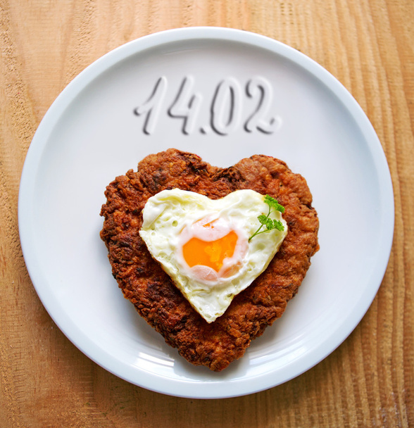Carne picada em forma de coração com ovo frito
 . - Foto, Imagem