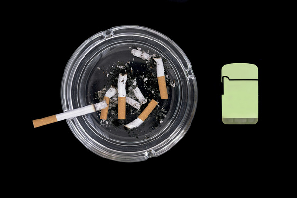 une cigarette allumée et quatre mégots dans le cendrier
 - Photo, image
