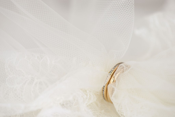 Velo de boda puesto a través de anillos de oro
 - Foto, Imagen