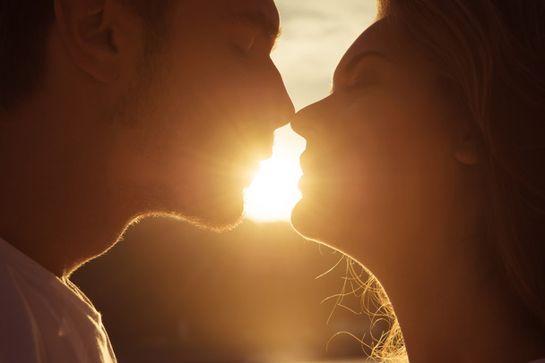 Close up portrait of two young lovers kissing on the sunset - 写真・画像