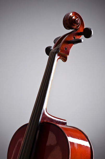 Музыкальная виолончель в темной комнате
 - Фото, изображение