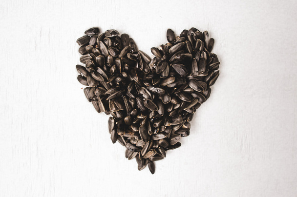 Black sunflower seeds on a white background - Foto, Imagen