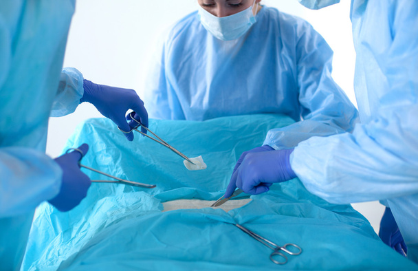 Команда хірурга в уніформі виконує операцію на пацієнта в клініці кардіохірургії
 - Фото, зображення
