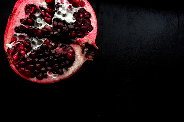 Delicious pomegranate fruit on black background - Photo, Image