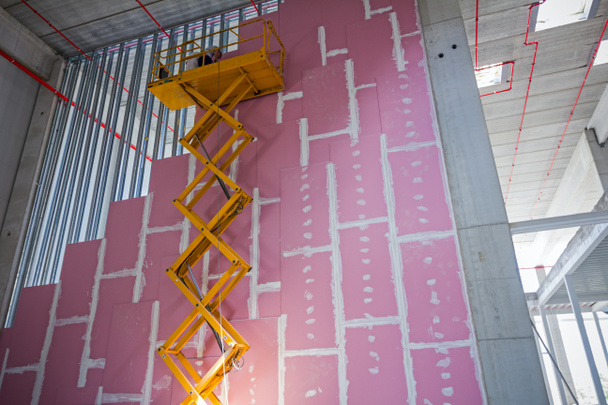 Plataforma elevadora de tijera en una obra de construcción
. - Foto, Imagen