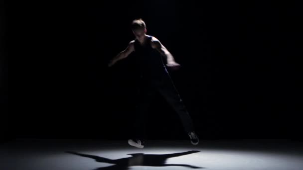 Young blonde dancer man dancing breakdance on black - Záběry, video