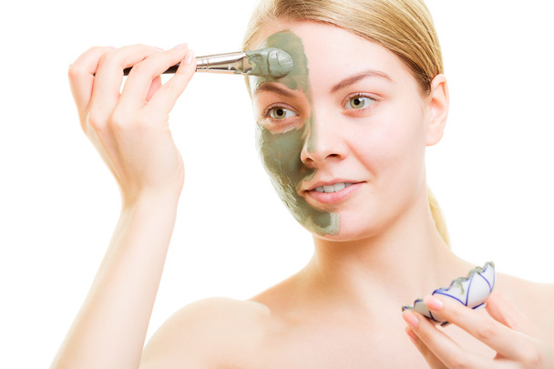 Girl applying facial clay mask to her face - Foto, immagini