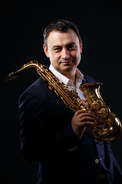 musician man with saxophone. drama light. - Fotografie, Obrázek