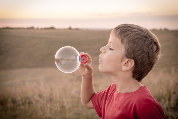 Boy blowing up the soap bubbles - Photo, Image