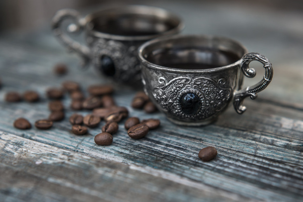 Czarna kawa w vintage srebrne kubki na drewniane tła - Zdjęcie, obraz
