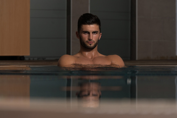Young Man Swimming In Pool At Resort - Foto, immagini