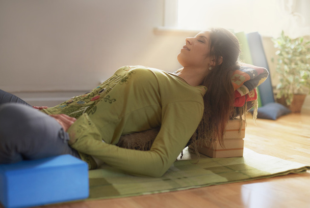 Attractive mixed race woman doing restorative yoga - Foto, Imagen