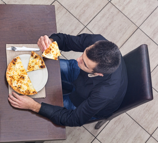 Young Man Eating Pizza - Фото, изображение