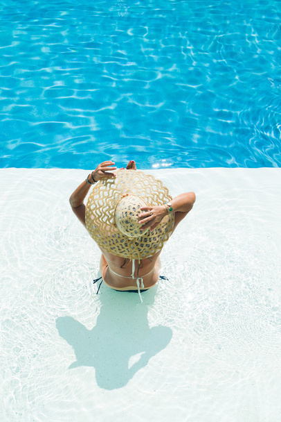 woman in a white hat sitting at the swimming  pool - Фото, зображення