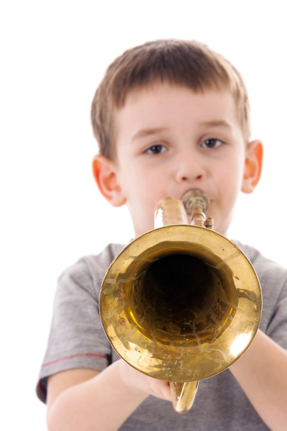 Jeune garçon soufflant dans une trompette sur fond blanc
 - Photo, image
