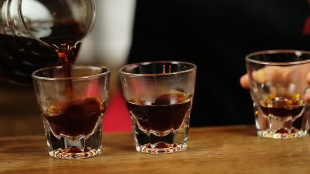 Lokale barista dragen zwart shirt met lege glazen te vullen met sterke lekkere koffie. - Video