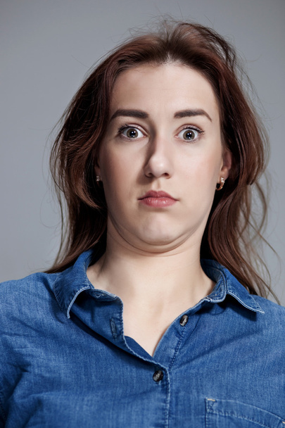 Portrait of young woman with shocked facial expression - Foto, afbeelding