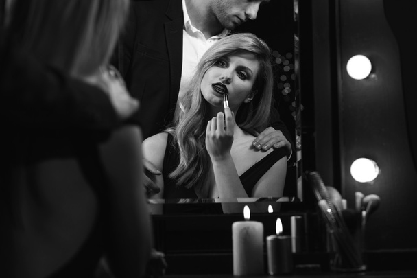 Seductive woman putting on lipstick - Foto, imagen