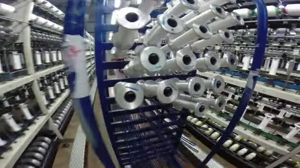 Kobiece pracownik opróżnia szpule przędzy bawełnianej przetworzonych w nowoczesnej fabryce tekstylnej - Materiał filmowy, wideo