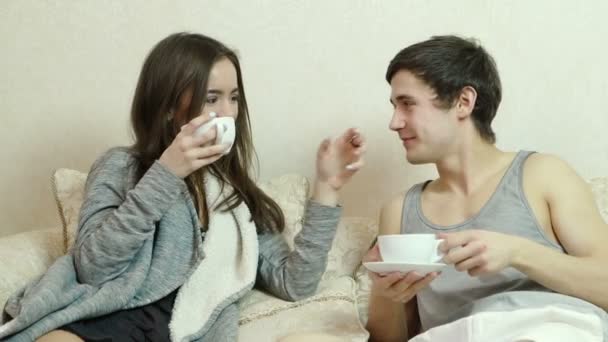 junges Mädchen flirtet, schnappt sich die Nase des Mannes, trinkt Tee (Kaffee)) - Filmmaterial, Video