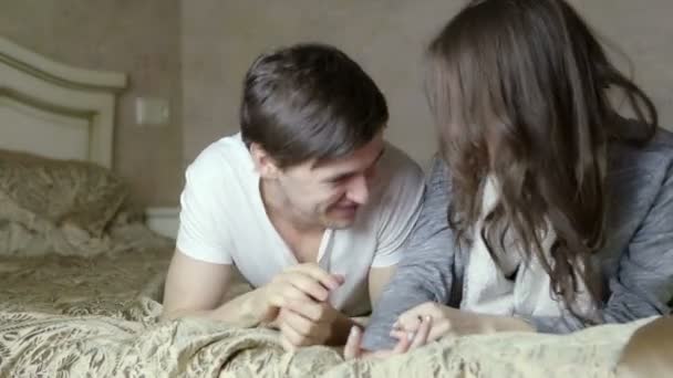 Boy and girl play the fool in bed. - Materiał filmowy, wideo