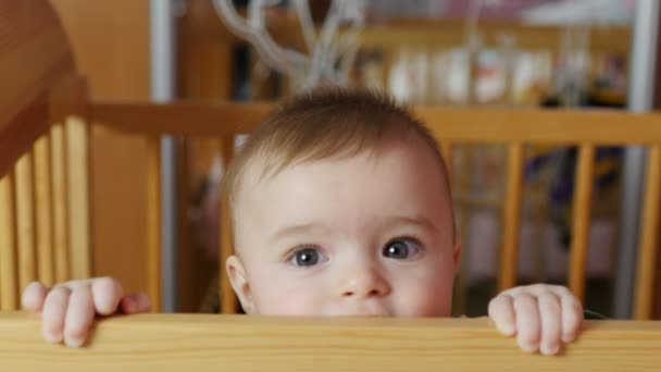 Babyjongen 5-6 maanden proberen te staan in een babybedje. Sluit het frame. - Video