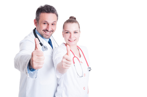 Ενθουσιασμένος άνδρας και γυναίκα γιατροί χαμογελώντας και δείχνοντας thumbup  - Φωτογραφία, εικόνα