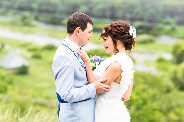 Mariée et marié au mariage Jour de marche En plein air sur la nature printanière. Heureux jeunes mariés embrassant dans le parc vert
. - Photo, image